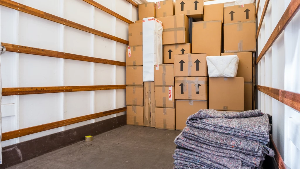 Interior of a moving truck with boxes and blankets organized for shipment.